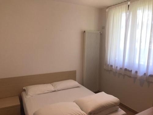 a small bedroom with a bed and a window at Casa Santa Maria in Folgaria