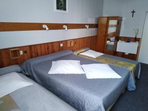 deux lits jumeaux dans une chambre avec un miroir dans l'établissement Chalet Saint Louis, à Lourdes