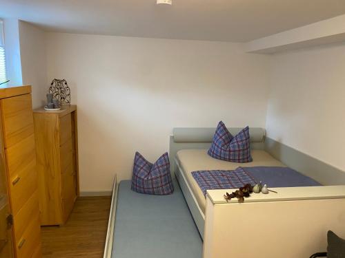 Dormitorio pequeño con cama con almohadas moradas en Saale Unstrut Ferienwohnung I, en Naumburg
