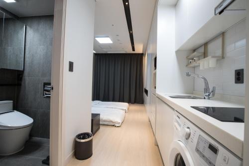 a small bathroom with a toilet and a sink at Sunrise Hotel Sokcho in Sokcho