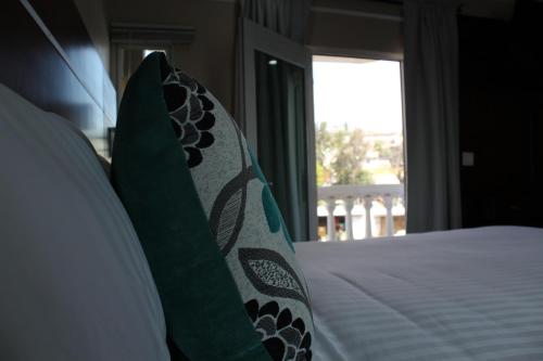 a bedroom with a bed with green pillows and a window at Hotel Cacaxtla in La Concordia