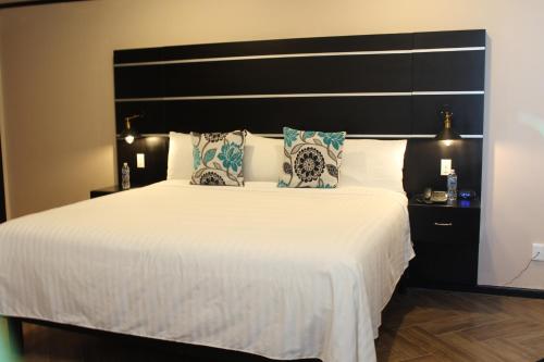 a bedroom with a large bed with a large headboard at Hotel Cacaxtla in La Concordia