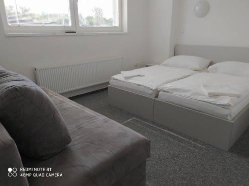 a bedroom with two beds and a couch at Penzion ValMez in Valašské Meziříčí