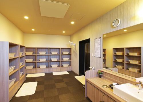 uma grande casa de banho com lavatório e prateleiras em Hotel Route-Inn Takefu Inter em Echizen