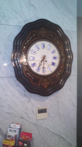 a large clock hanging on a wall at Rigel Hotel in Catania