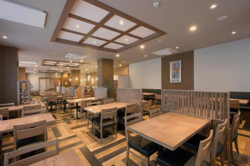 a dining room with wooden tables and chairs at Hotel Route-Inn Yamagata Minami -Daigaku Byoin Mae- in Yamagata