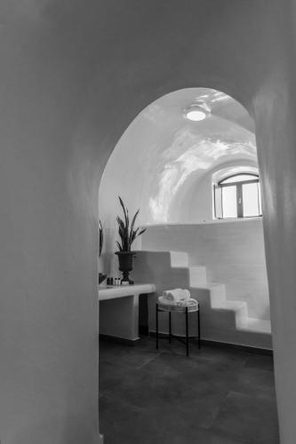 a white room with a table and a potted plant at Doukas Caldera Suites in Fira