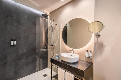 a bathroom with a sink and a mirror at Occidental Sevilla Viapol in Seville