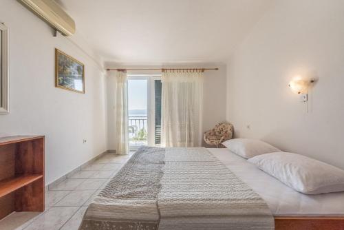 a bedroom with a large bed and a window at Apartments Kod Cara in Lokva Rogoznica