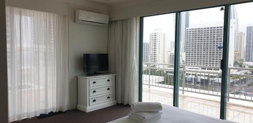 a bedroom with a bed and a tv and a large window at Crown Towers Resort Private Apartments in Gold Coast