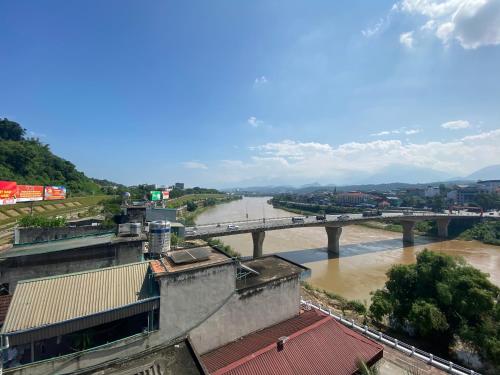 Blick auf einen Fluss mit einer Brücke im Hintergrund in der Unterkunft Van Anh Motel in Cốc Lếu