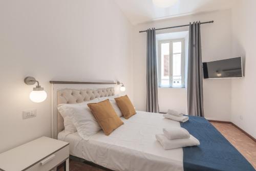 um quarto branco com uma grande cama branca com almofadas em Vicolo del Cinque Apartment Trastevere em Roma