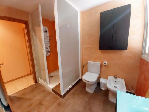 a bathroom with a toilet and a television on the wall at El Vergel del Piedra in Munébrega