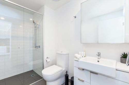ein weißes Bad mit einem WC und einem Waschbecken in der Unterkunft KOZYGURU FORTITUDE VALLEY AMAZING VIEW 2BED APT + FREE PARKING QFV010 in Brisbane