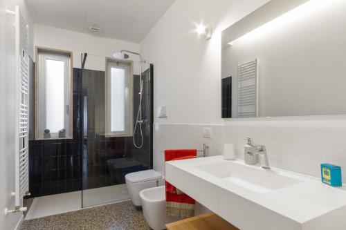 ein Badezimmer mit einem Waschbecken, einem WC und einem Spiegel in der Unterkunft Inner City Apartments in Lecce