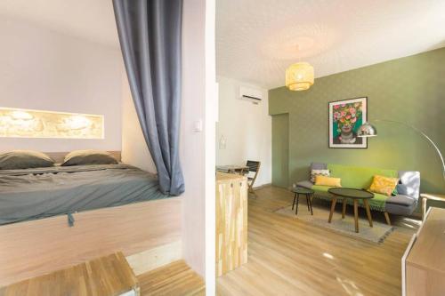 a bedroom and a living room with a bed and a table at Mini maison studio Ancienne Rénovée +Parking in Avignon