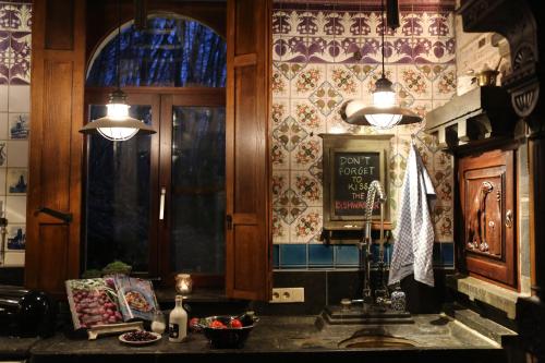 a kitchen with two lights and a wall with tiles at Trumpet House in Leuven