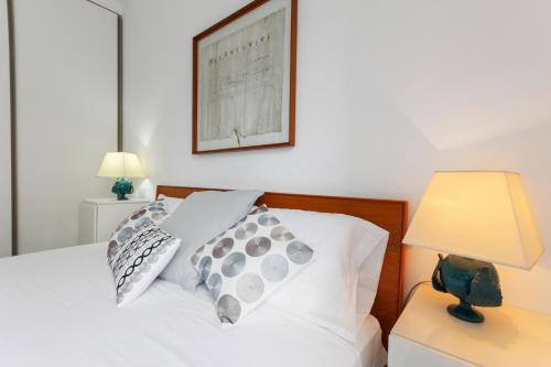 łóżko z dwoma poduszkami i zdjęciem na ścianie w obiekcie Inner City Apartments w mieście Lecce