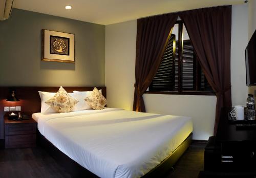 a bedroom with a large white bed and a window at Kimberley Hotel Georgetown in George Town