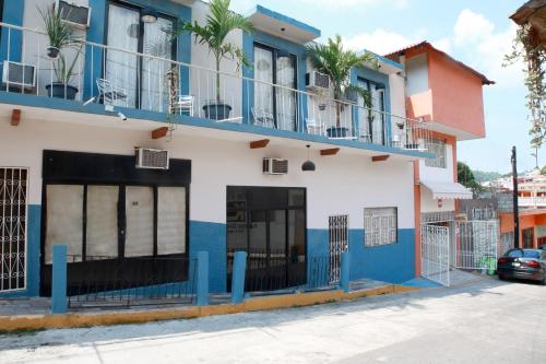 un bâtiment bleu et blanc avec une voiture garée devant dans l'établissement OYO Hotel Maria Otilia Falla, Papantla, à Papantla