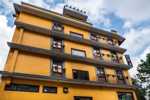 een geel gebouw met balkons aan de zijkant bij Capital O Hotel Central, Xalapa in Xalapa