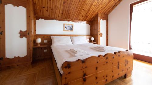 a bedroom with a wooden bed with two towels on it at Italianway - Besta 2 in Bormio