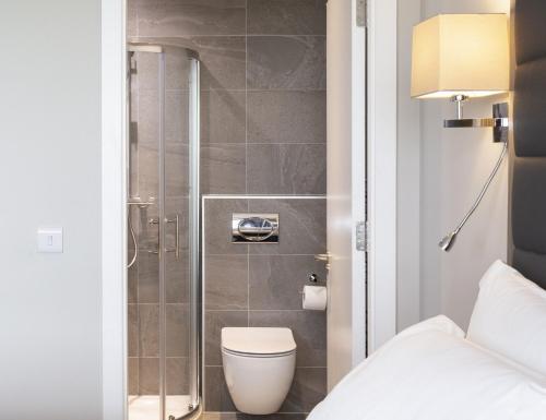 La salle de bains est pourvue d'une douche et de toilettes. dans l'établissement Metro Apartments Dublin Airport, à Dublin
