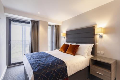 a hotel room with a bed and a large window at Metro Apartments Dublin Airport in Dublin