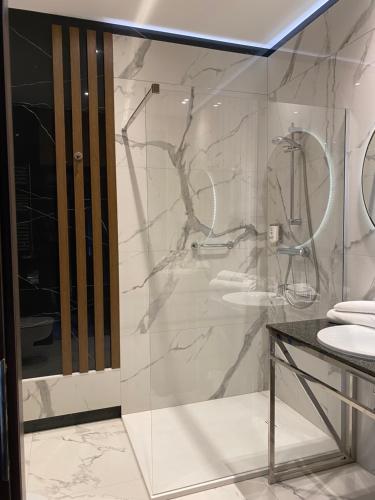 W łazience znajduje się szklana kabina prysznicowa i umywalka. w obiekcie Hotel Falko w mieście Rumia