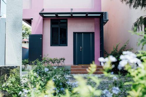 埔里鎮的住宿－以馬內利森林民宿，粉红色的房子,设有绿门