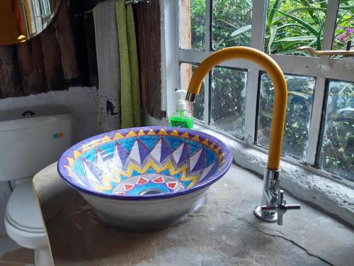 a bathroom with a mosaic sink and a toilet at Aloepark Art Hotel in Naivasha