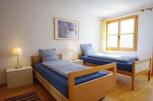 - une chambre avec 2 lits et une fenêtre dans l'établissement Haus Liaun 2, à Brienz