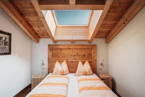 2 Betten in einem Schlafzimmer mit Dachfenster in der Unterkunft Apartment Lahnbach Grosskarneid in Lüsen