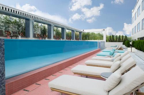a row of chaise lounge chairs next to a swimming pool at Mondrian Seoul Itaewon in Seoul