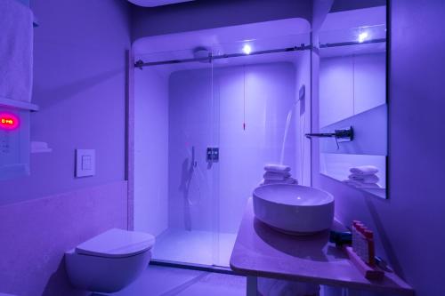 a bathroom with a sink and a shower and a toilet at Hangar Hotel in Teverola