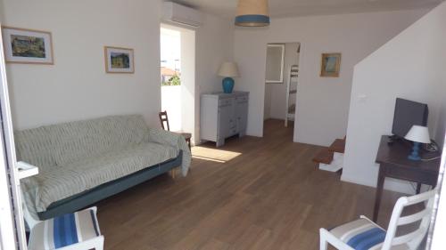 uma sala de estar com um sofá e uma mesa em Villa T5 climatisée - Front de Mer - Narbonne Plage em Narbonne Plage
