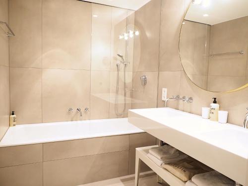 a bathroom with a tub and a sink and a shower at Jugend- und Familienhotel Augustin in Munich