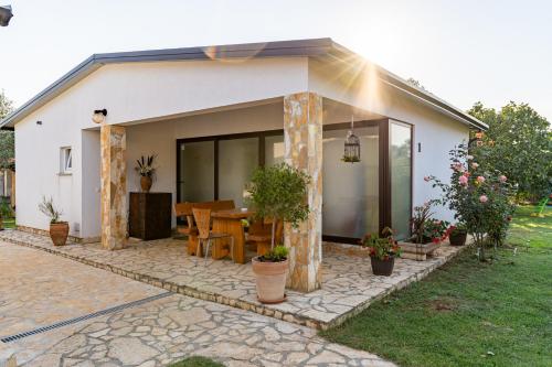 une petite maison blanche avec une table et quelques plantes dans l'établissement Holiday Home Kerniat, à Šišan