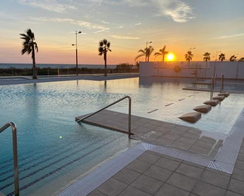 basen z zachodem słońca w tle w obiekcie Apartamento Lujo Duna Beach w mieście Torrox Costa