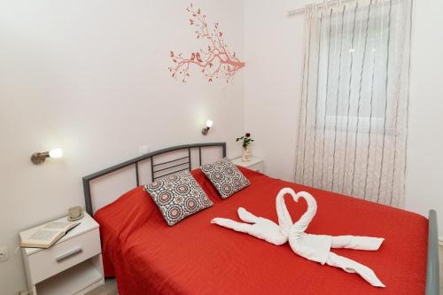 a bedroom with a red bed with two white towels at Holiday Home Kerniat in Pula