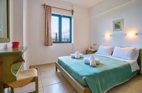 a bedroom with a bed with towels on it at Dionysos Apartments & Studios in Stalida