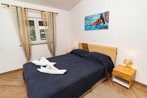 a bedroom with a bed with white shoes on it at Holiday Home Kerniat in Pula