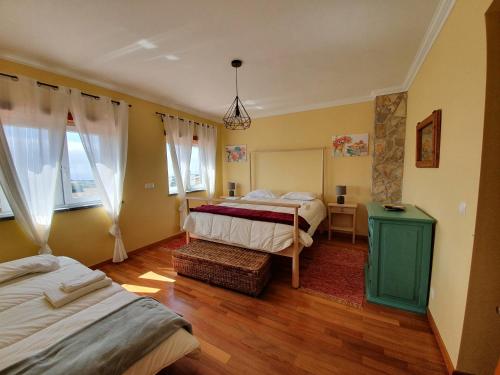 Un dormitorio con dos camas y una mesa y dos ventanas. en Mia's House, en Casa Nova