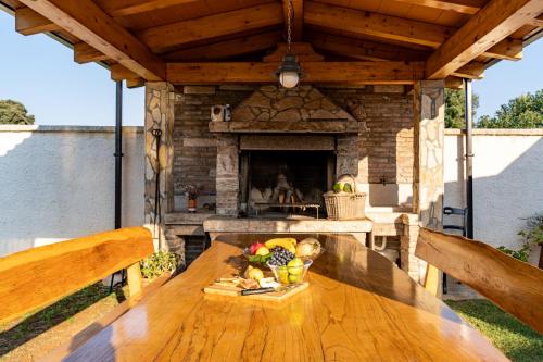 a wooden table in front of a stone fireplace at Holiday Home Kerniat in Pula