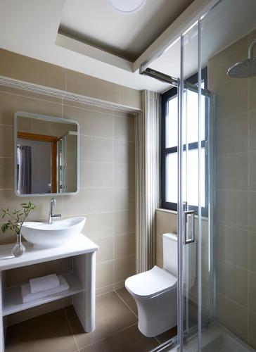 a bathroom with a sink and a toilet and a mirror at Karvouno Villas in Sivota