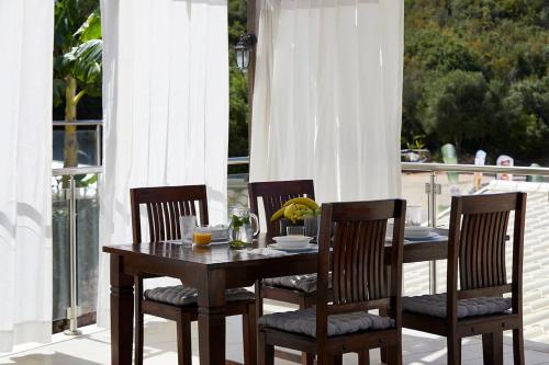 a wooden table and chairs on a porch with a table and a table at Karvouno Villas in Sivota