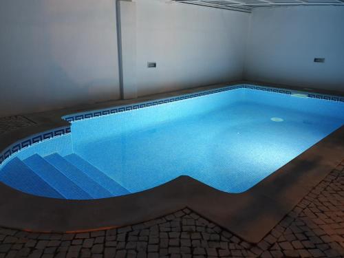 a large swimming pool with blue water in a room at Mia's House in Casa Nova