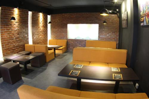 a waiting room with yellow chairs and tables at Richmond Hotel & Suites in Dhaka