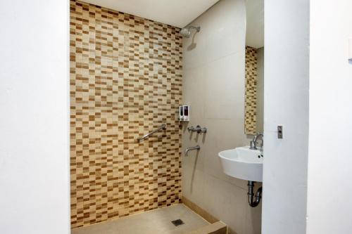 uma casa de banho com um lavatório e um chuveiro em Carani Hotel Yogyakarta em Yogyakarta