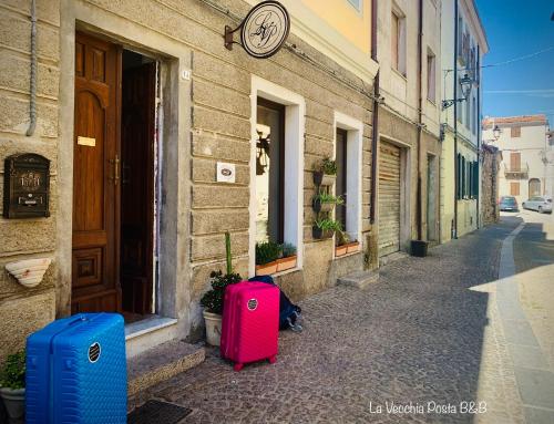 two suitcases are sitting outside of a building at La Vecchia Posta B&B in Calangianus